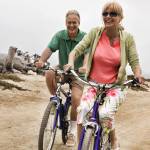 Portrait of middle aged Couple Riding Bikes along Beach