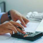 Man doing finances and calculate about cost to real estate investment and in other, tax system.Time for Taxes Money Financial Accounting Taxation Concept