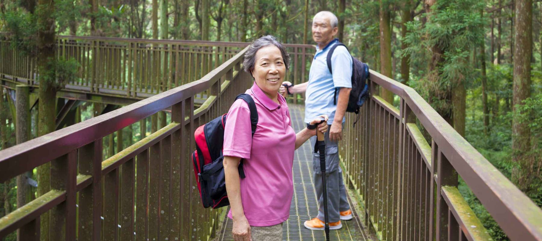 happy senior hiking in the forest park
