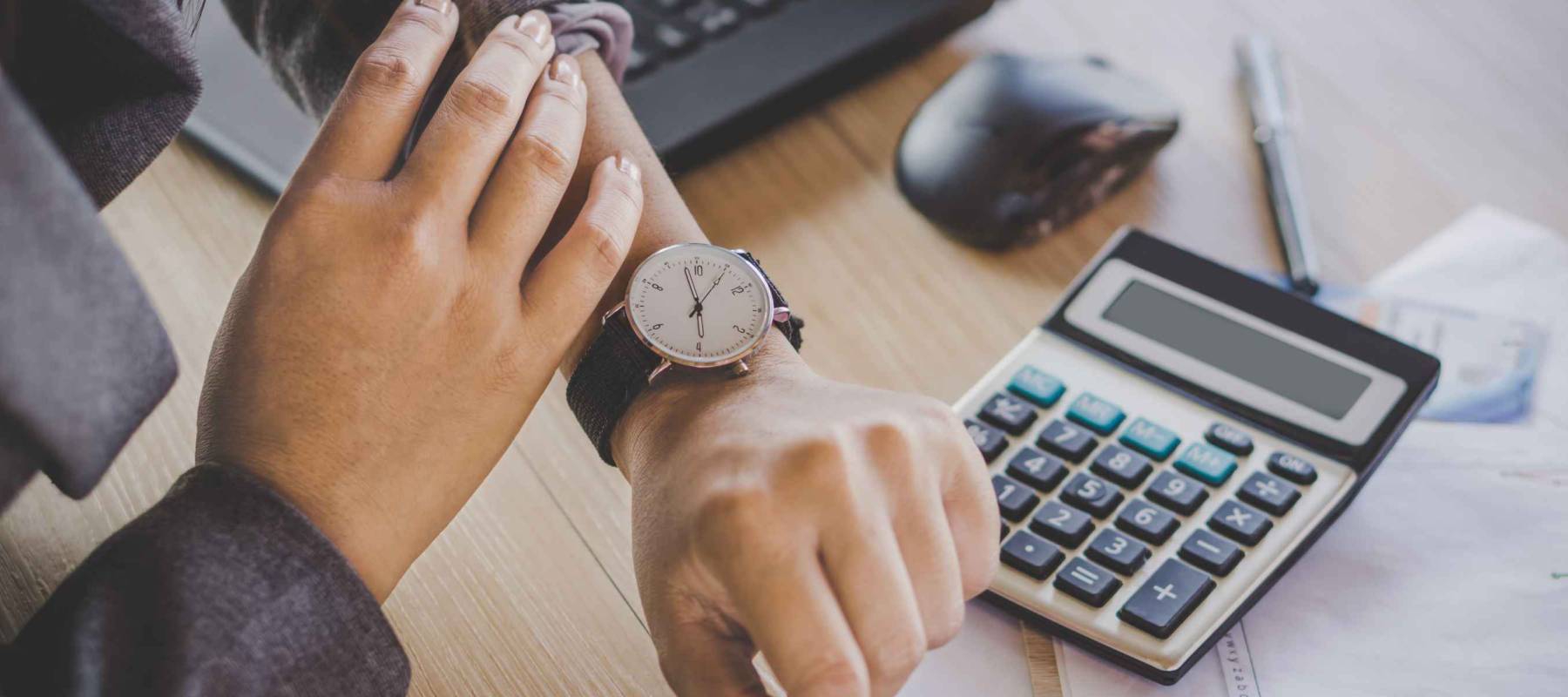 businesswoman boss checking the time on watch waiting for partners coming late sitting at her desk office