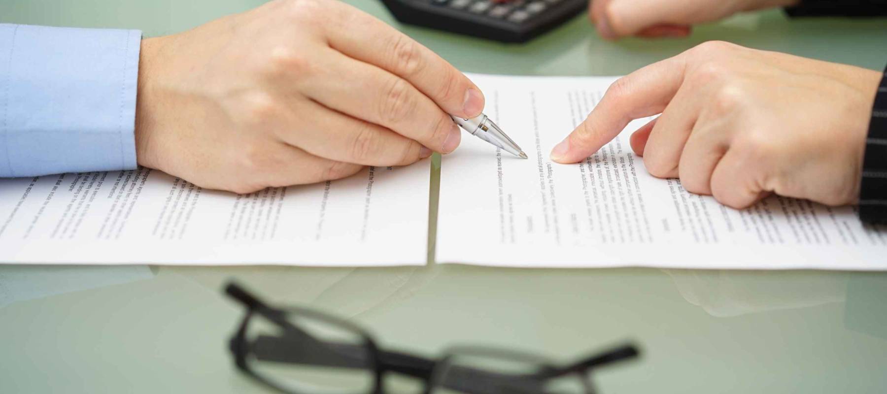 businesswoman is reviewing document with tax consultant and making calculations to optimize report