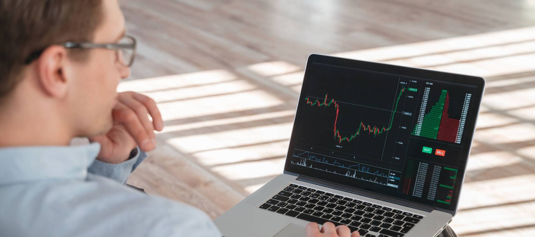 Close up shot of trade investor sitting with laptop on knees,