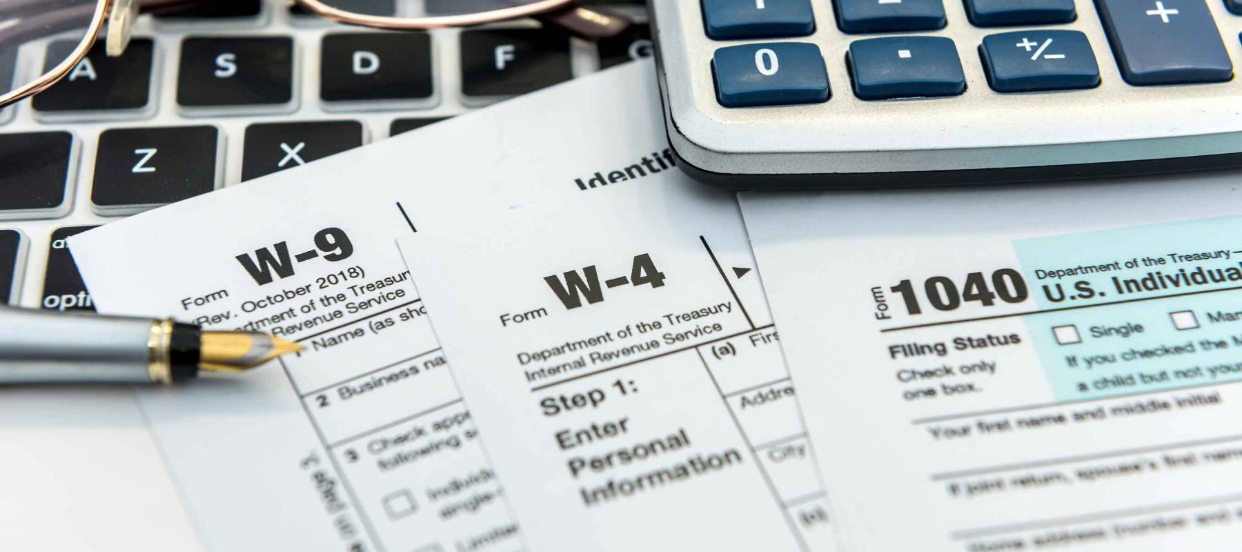 Financial time tax form with laptop and calculator. Office paperwork. Accounting