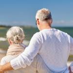family, age, travel, tourism and people concept - happy senior couple hugging on summer beach
