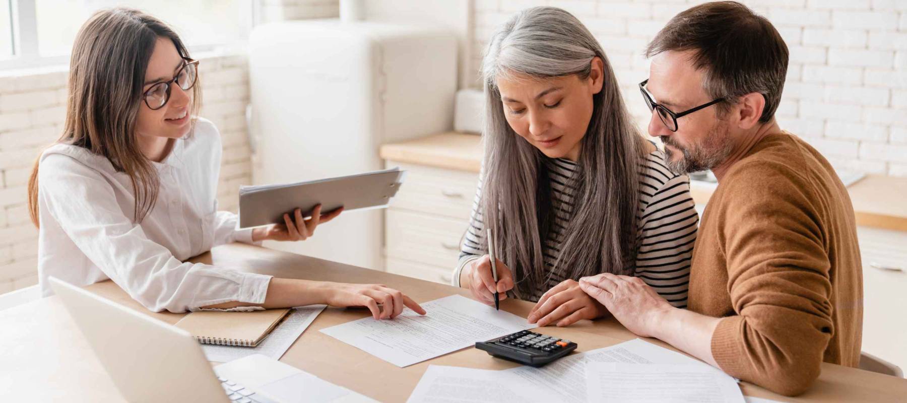 Insurance agent consulting mature family couple, discussing health insurance, signing contract deal of loan pension mortgage at home, calculating funds, investments, savings