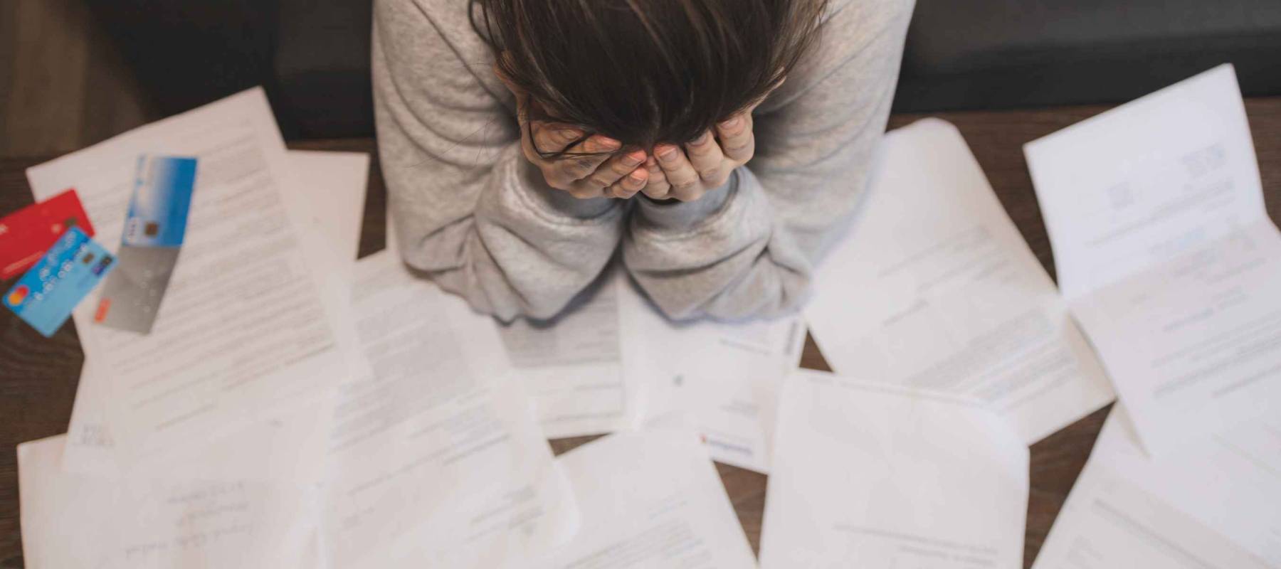 Shocked stressed young woman reading document letter from bank about loan debt financial problem