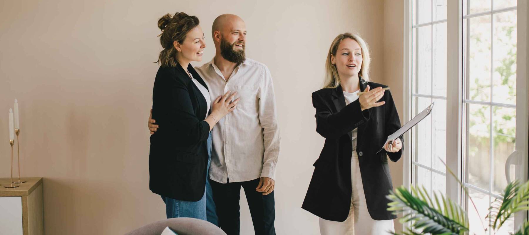 Real estate agent demonstrating a new apartment to a happy couple. Buying a property.
