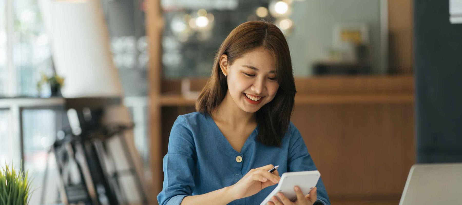 Portrait of asian business woman paying bills online with laptop in office.