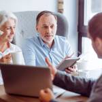 Positive aged couple consulting with insurance agent