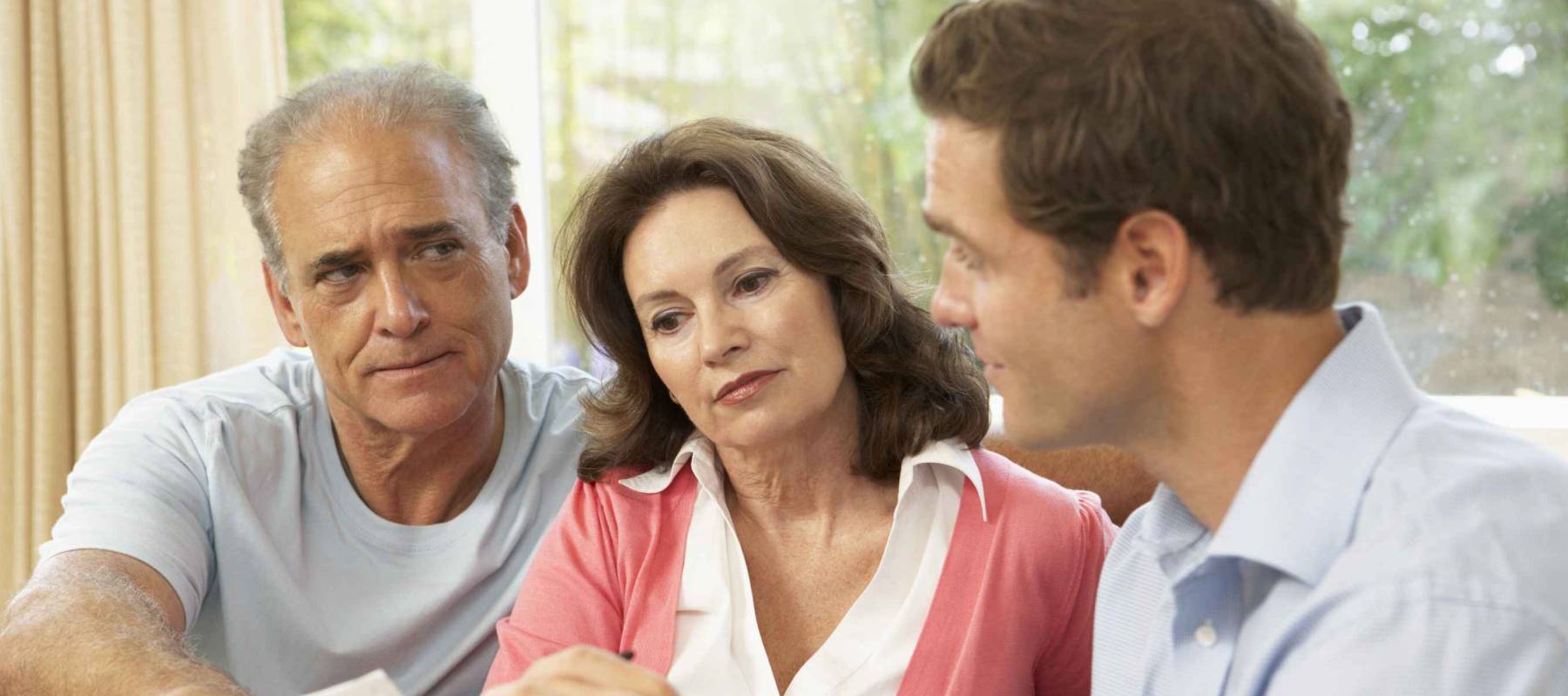 Senior Couple With Financial Advisor At Home