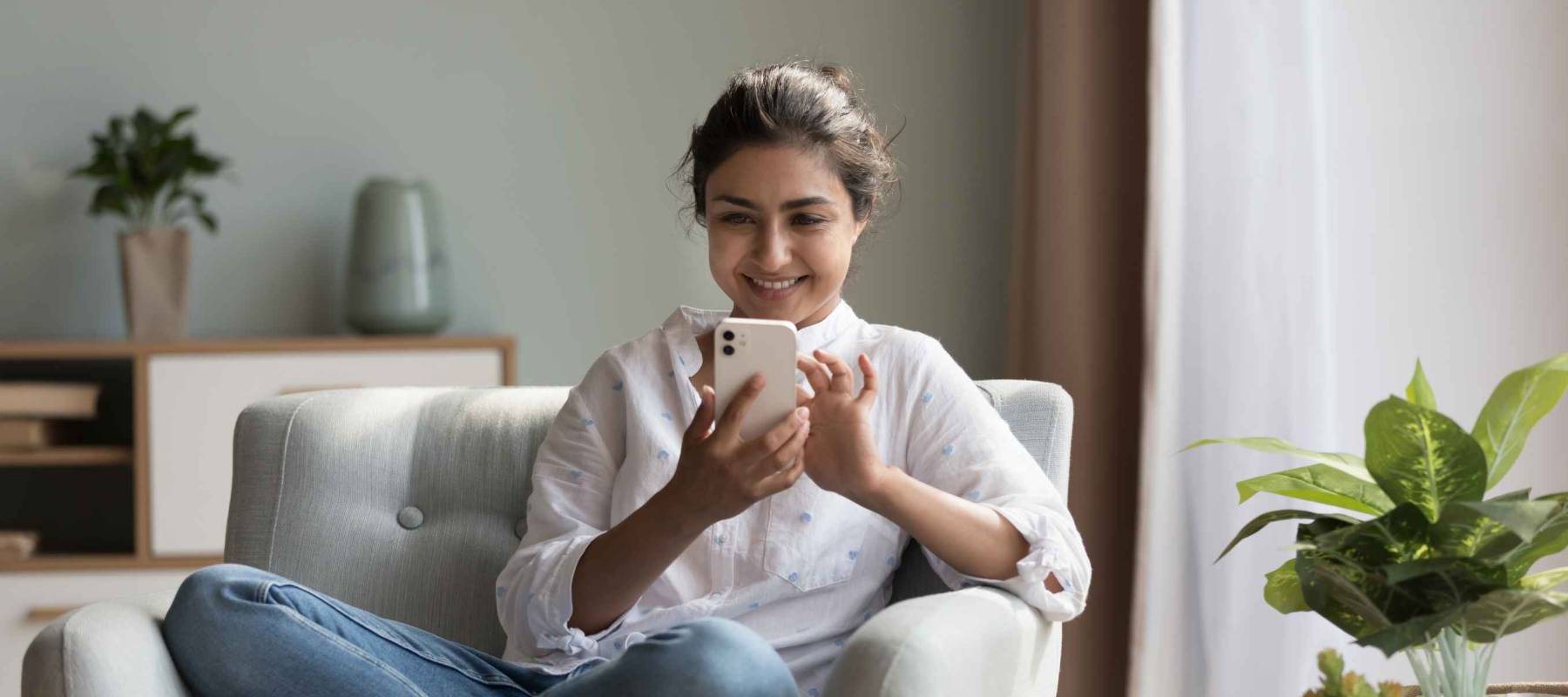 Happy pretty millennial Indian girl relaxing at home