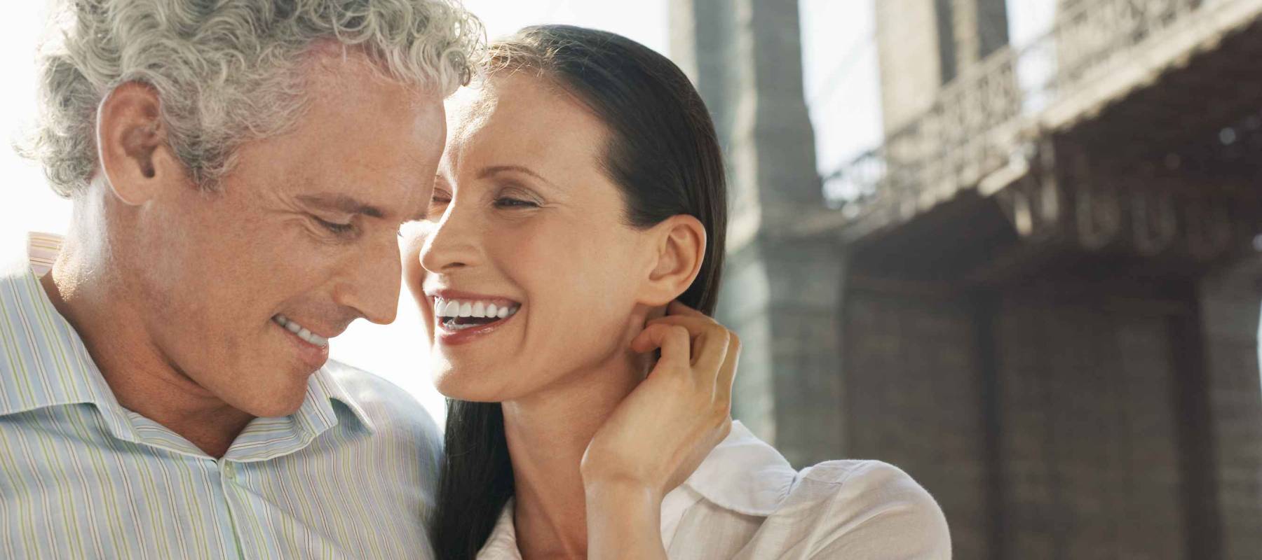 Caucasian couple smiling with bridge in the background