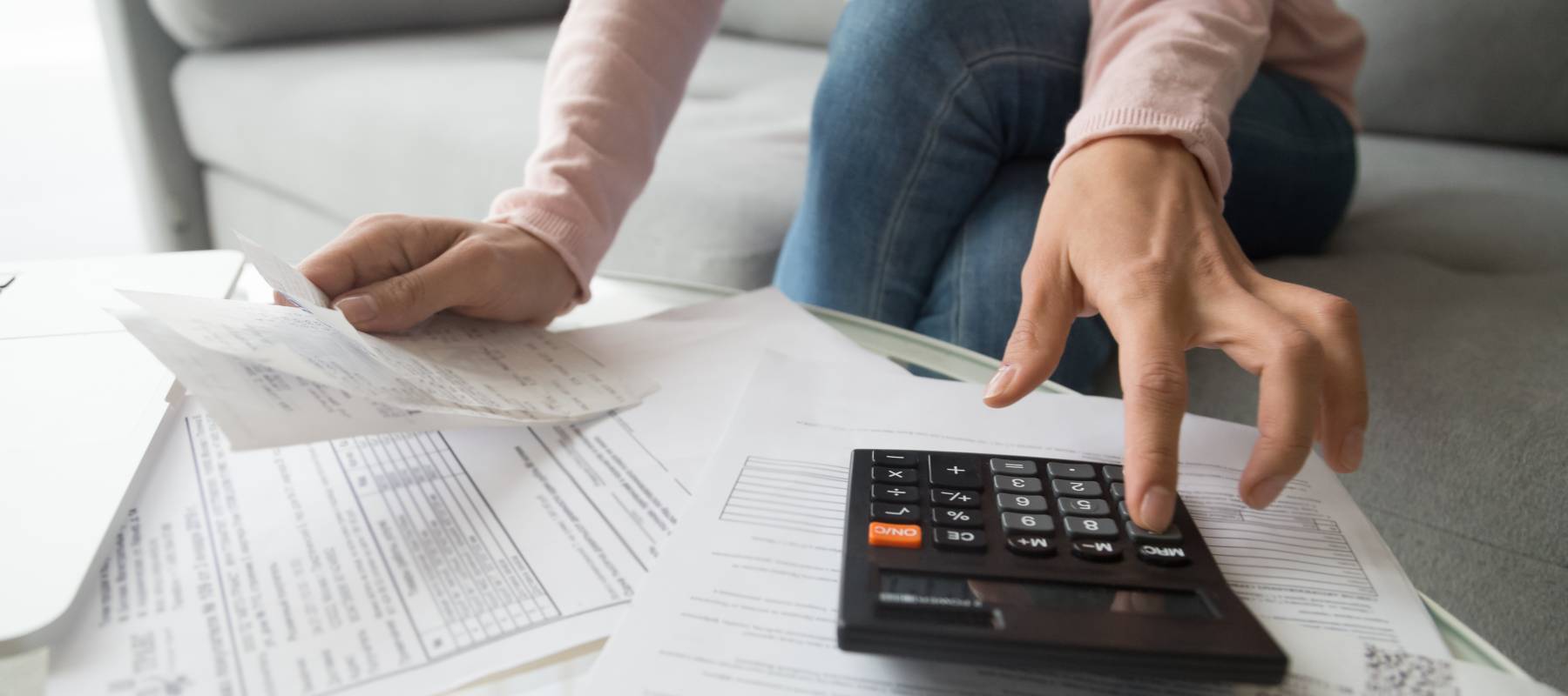 Woman renter holding paper bills using calculator for business financial accounting