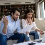 Couple reviewing bills feels stressed having financial problem