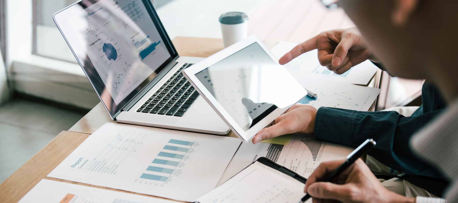 Business partnership coworkers using a tablet to analysis graph company financial budget report and cost work progress and planning for future in office room.