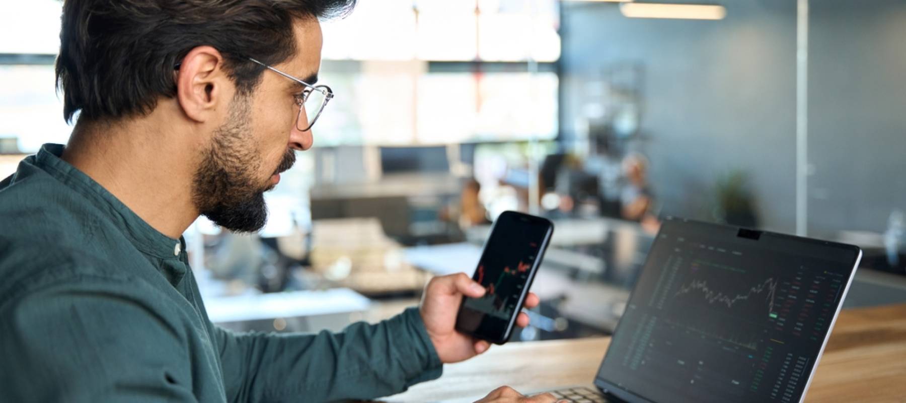 Man on phone checking stocks