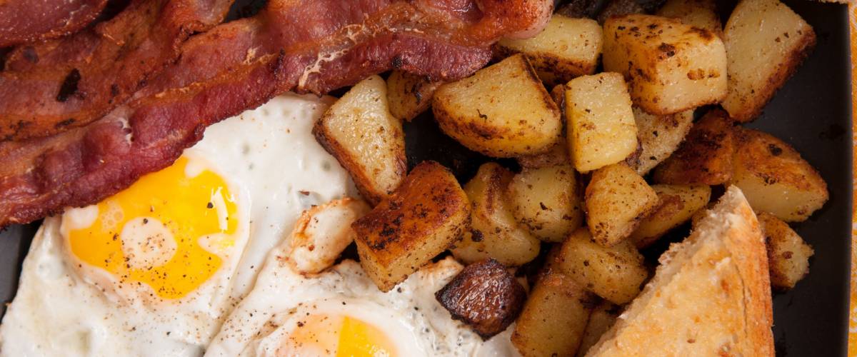 Bacon and eggs with toast and home fries.