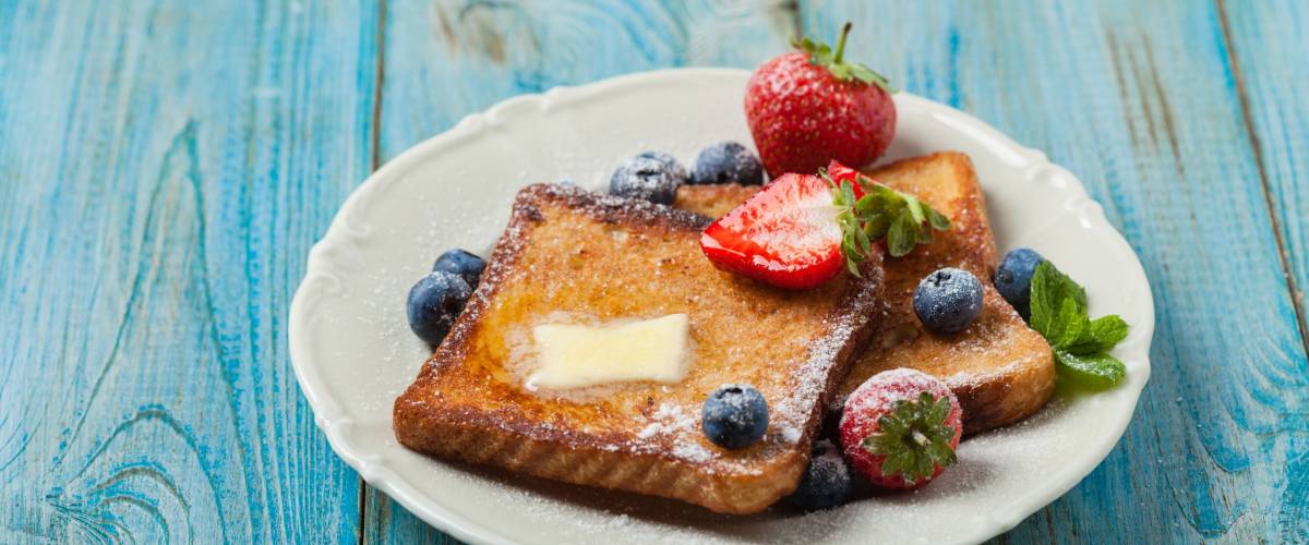 Traditional, delicious, sweet French toast with fruit and butter.
