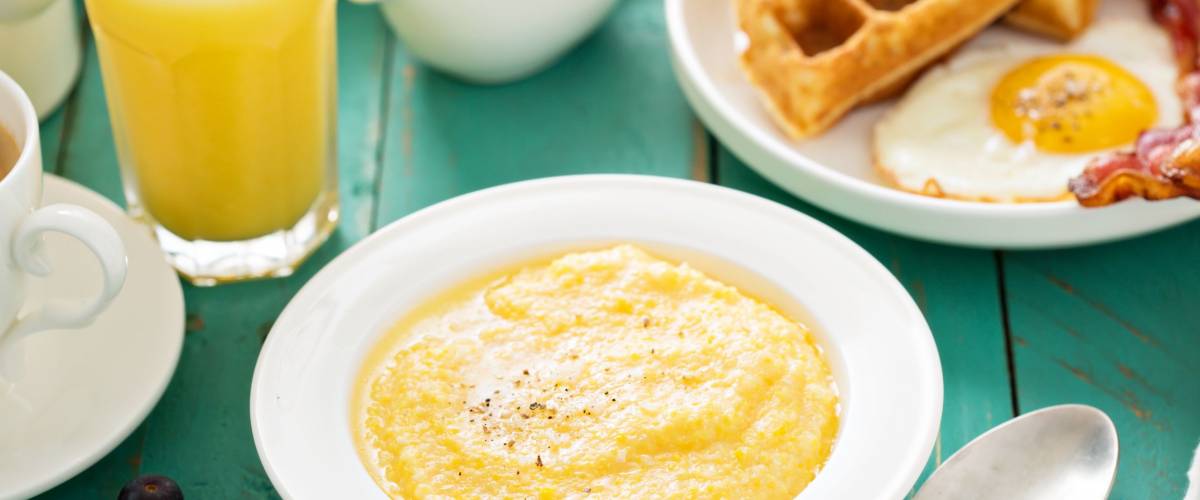 Cheesy grits with butter in a white bowl for breakfast