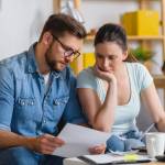 Family with a child having financial problems, doing home budgeting, calculating expenses.