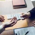 Entrepreneurs are receiving money that is a bribe of their partners with both of whom are corrupt in the company room.