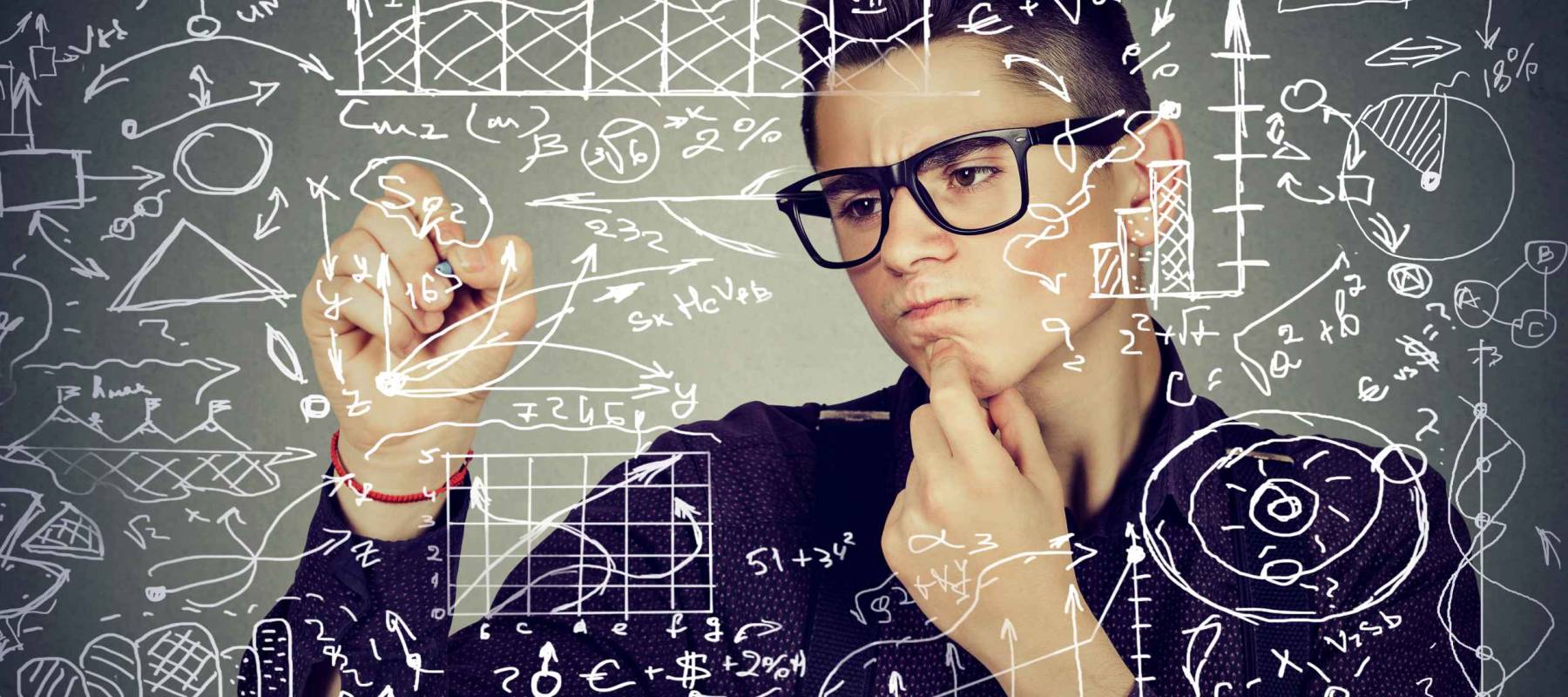 Smart young business man writing formulas or science financial calculations