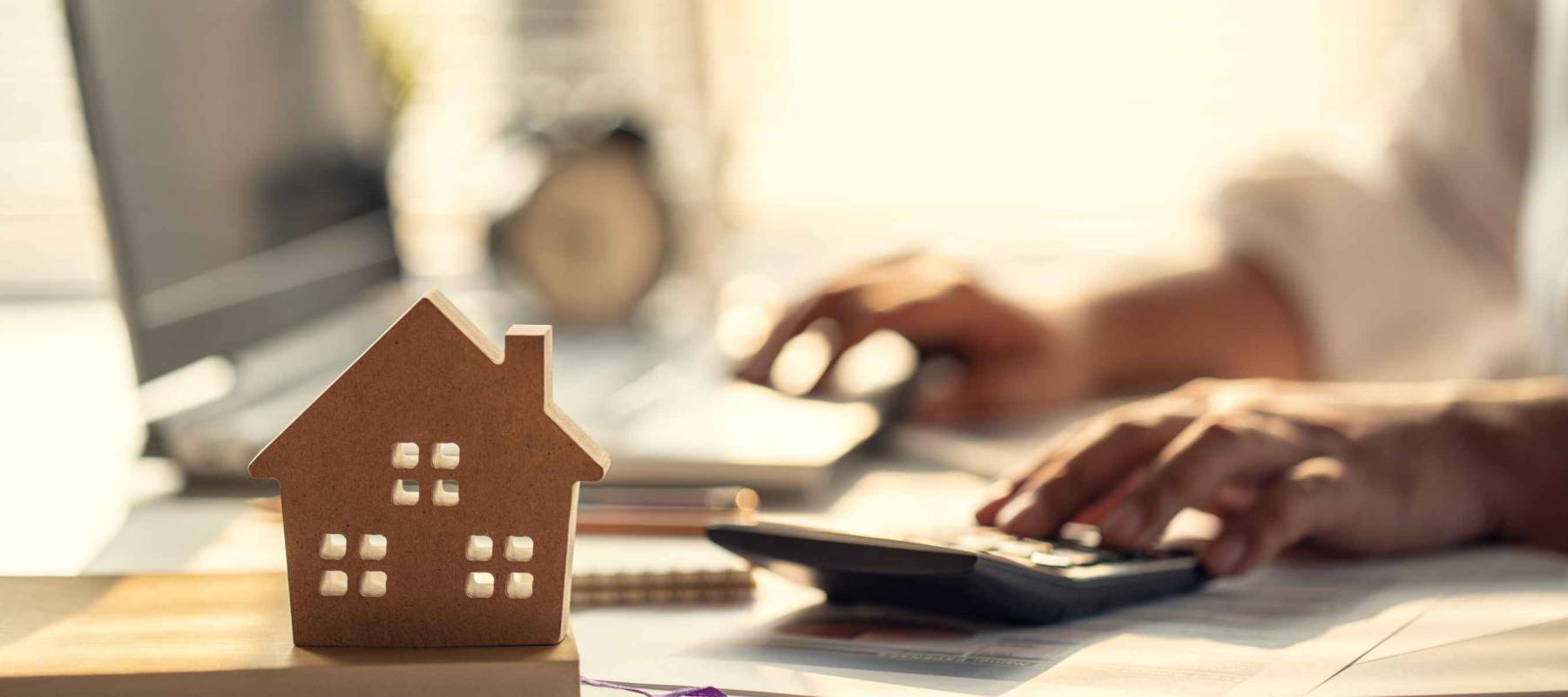 Hand of Business people calculating interest, taxes and profits to invest in real estate and home buying