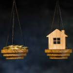 The scales with the coins and the home of the imitation of bamboo. The concept of purchasing housing, credit, and quotes on the real estate market.