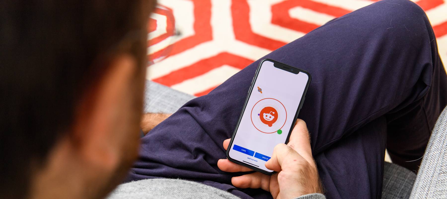 Man using the new Apple iPhone Xs with the immense OLED retina display and a12 bionic chip, looking over the app application Reddit news community app