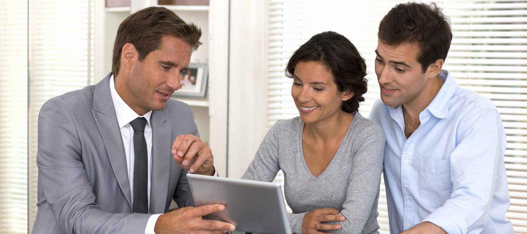 Financial consultant presenting a new project investment to a smiling young couple