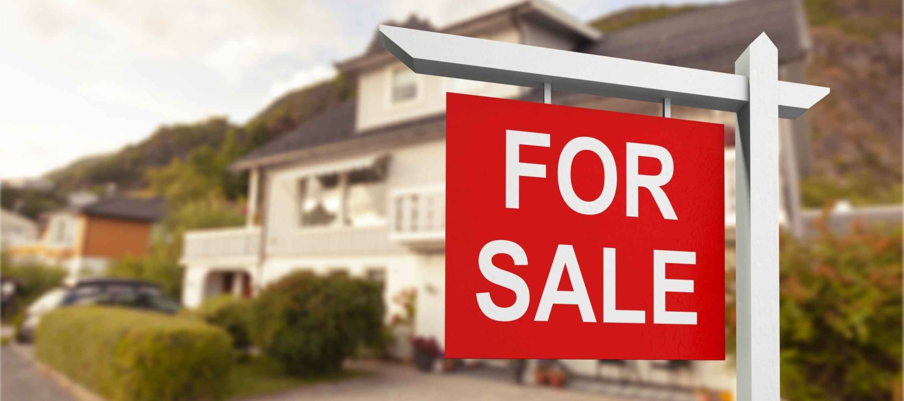 Real estate sign in front of new house for sale