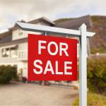 Real estate sign in front of new house for sale
