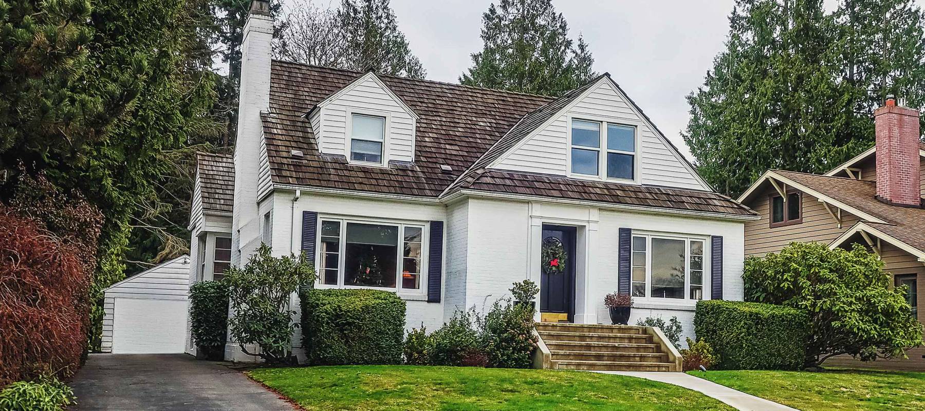 white colonial style suburban house with front walkway