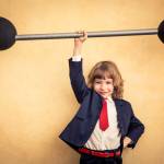 Strong businessman child holding barbell. Success and winner business concept
