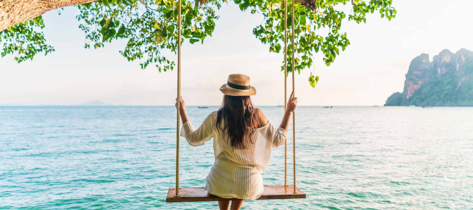Traveler woman relaxing on swing above Andaman sea Railay beach Krabi, Leisure tourist travel Phuket Thailand summer holiday vacation trip,