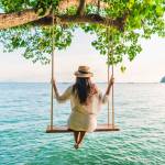 Traveler woman relaxing on swing above Andaman sea Railay beach Krabi, Leisure tourist travel Phuket Thailand summer holiday vacation trip,