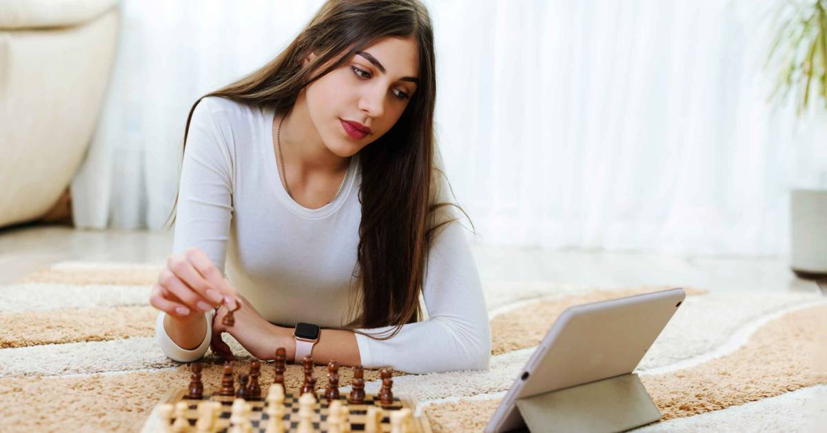 Premium Photo  Woman playing chess online uses laptop