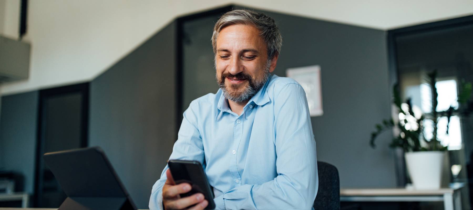Businessman taking a break from work and using his phone.