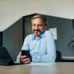 Businessman taking a break from work and using his phone.