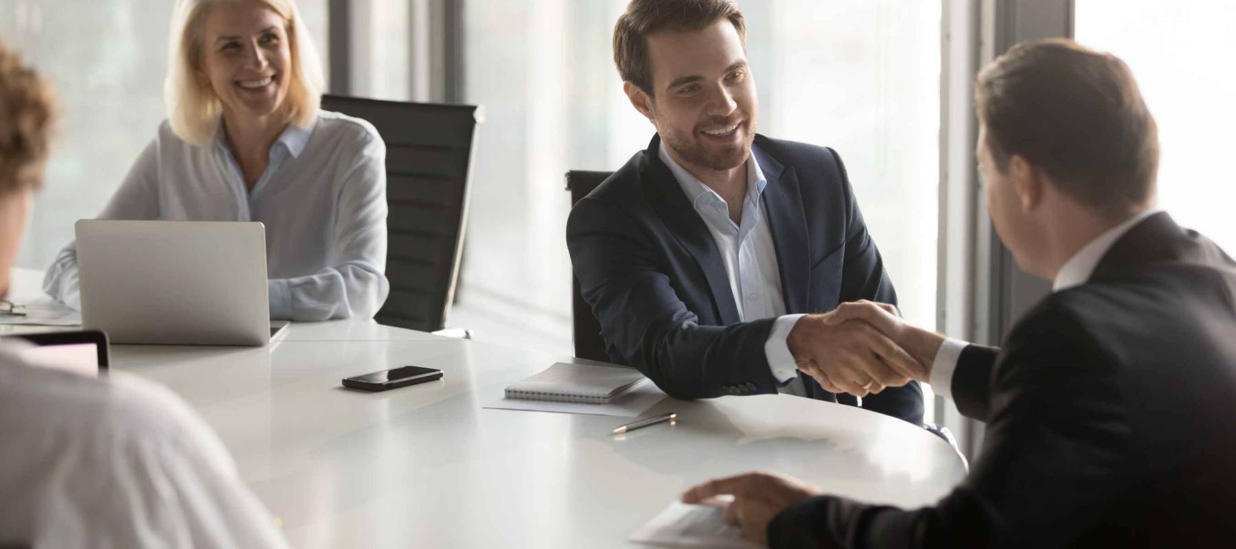 Happy business partners shaking hands expressing respect, closing banking investment corporate deal, welcoming at office group meeting
