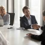 Happy business partners shaking hands expressing respect, closing banking investment corporate deal, welcoming at office group meeting