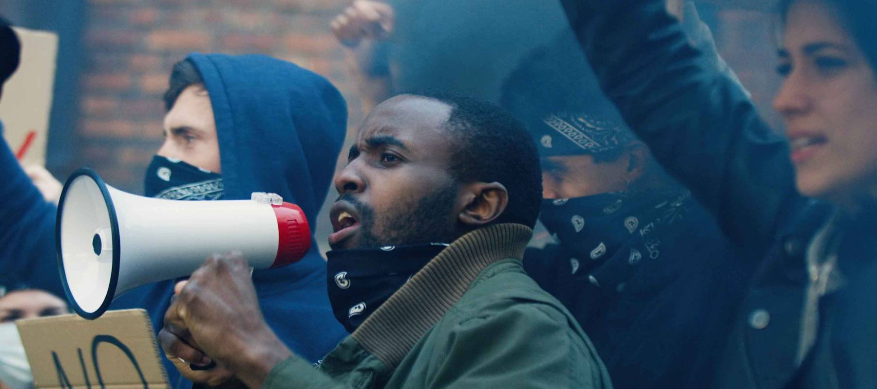 Male and female multiethnic pretesters screaming slogans and protesting