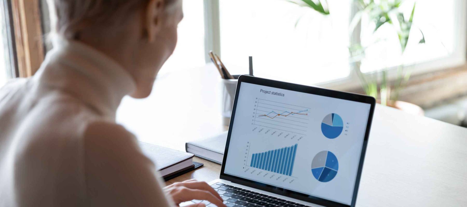 Rear view close up businesswoman working with financial project statistics