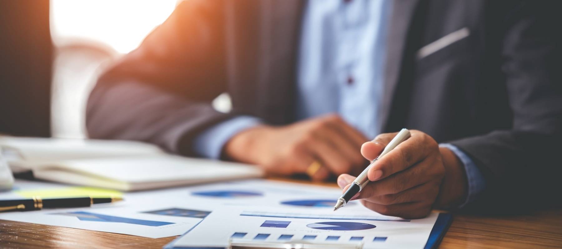 Business man analyzing the business price chart on the desk at the meeting room in the morning