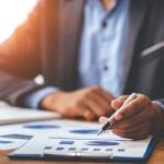 Business man analyzing the business price chart on the desk at the meeting room in the morning