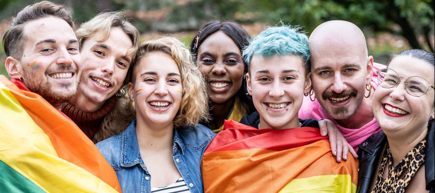 Group of young activist for lgbt rights with rainbow flag, diverse people of gay and lesbian community