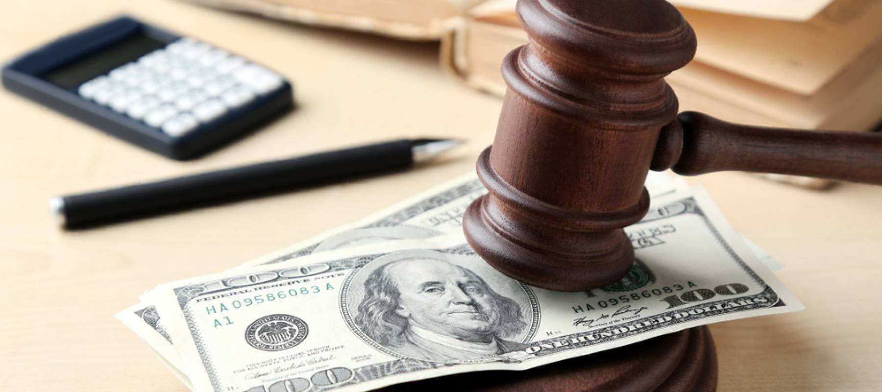 Judge gavel with dollars on wooden table