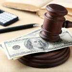 Judge gavel with dollars on wooden table