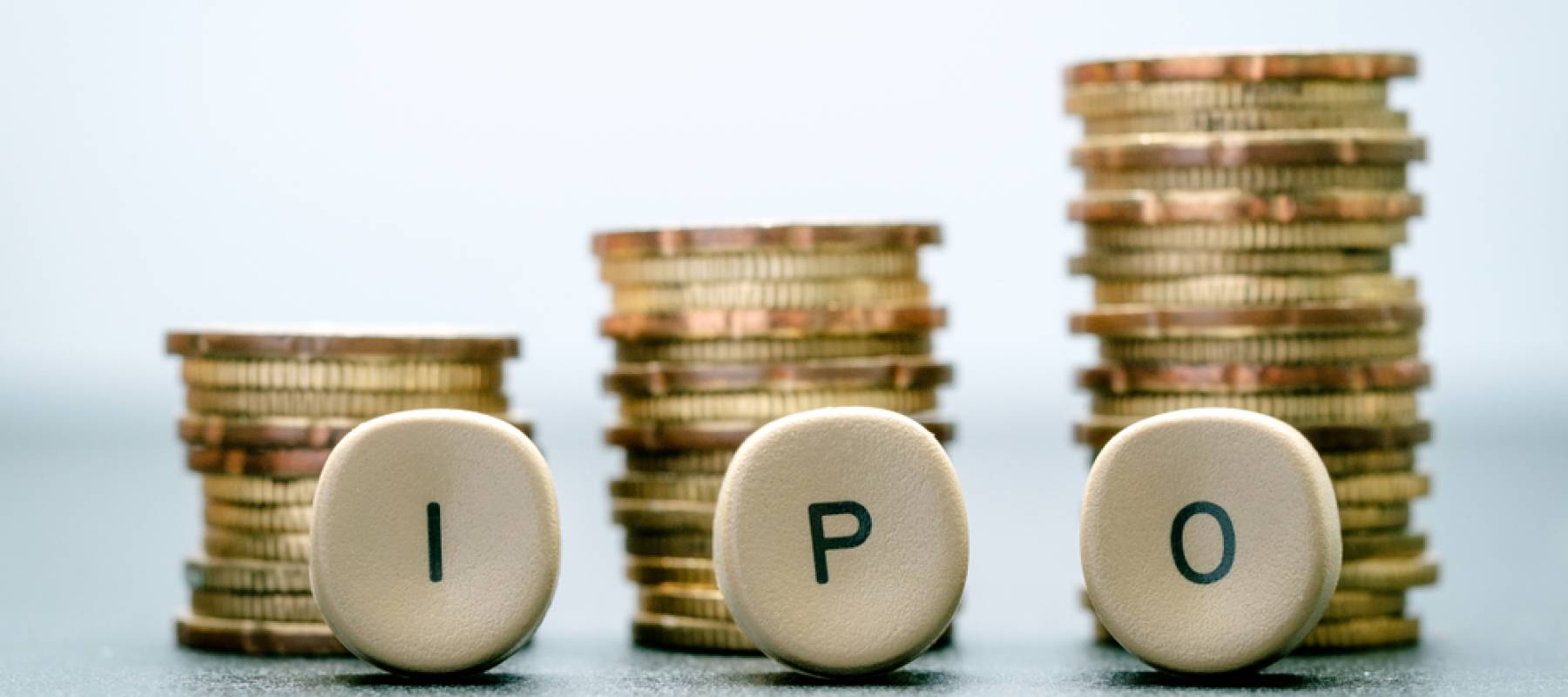 IPO letter blocks and stacked coins. IPO stands for Initial Public Offering.