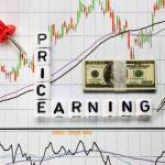Price and Earning letter cube on candle stick chart background. Investment concept for P/E ratio.